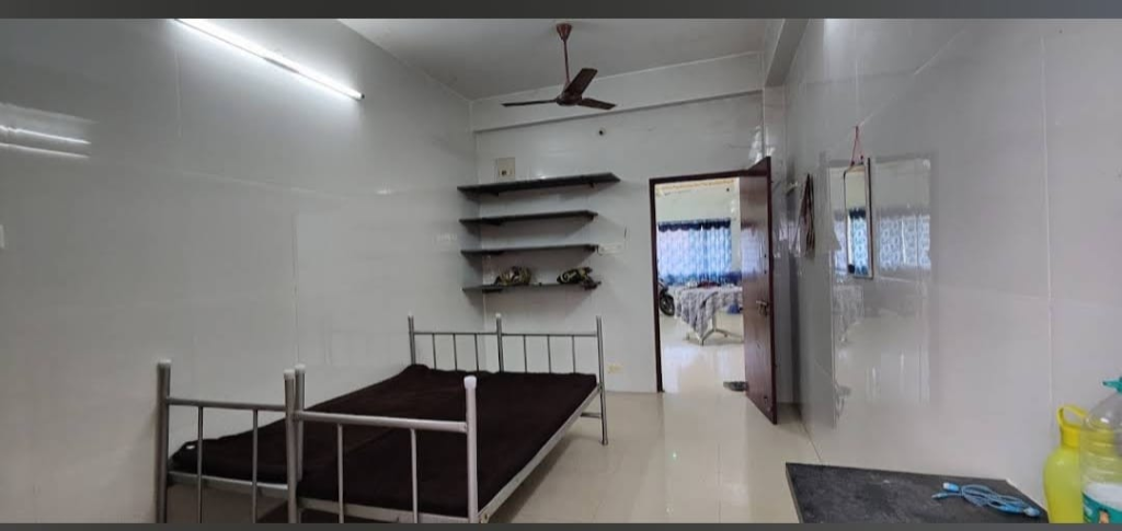 Ashok Nest Deluxe Room with Bed and Wall Shelves